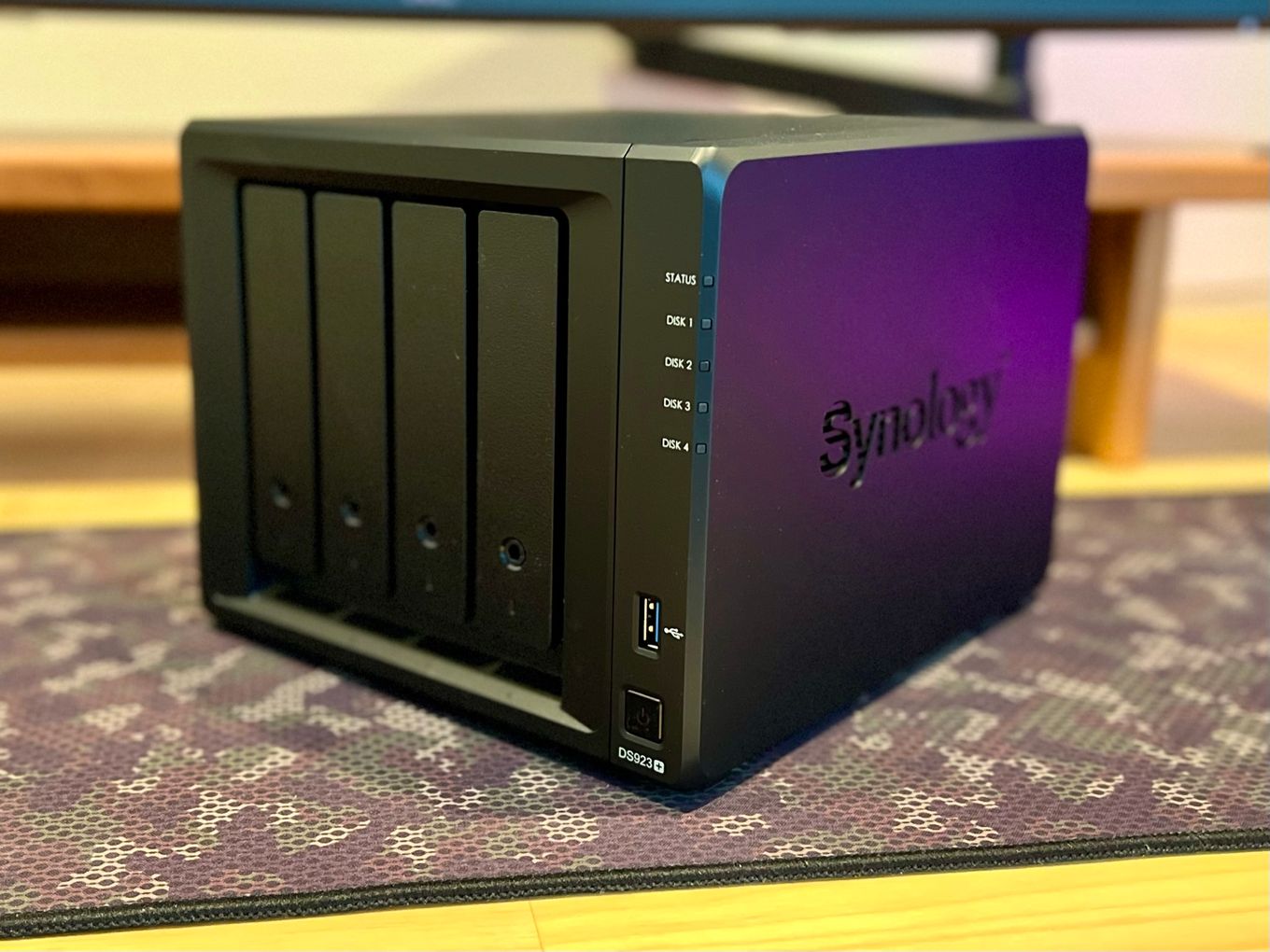 A photo of a Synology DS923+ NAS device sitting on a computer desk.