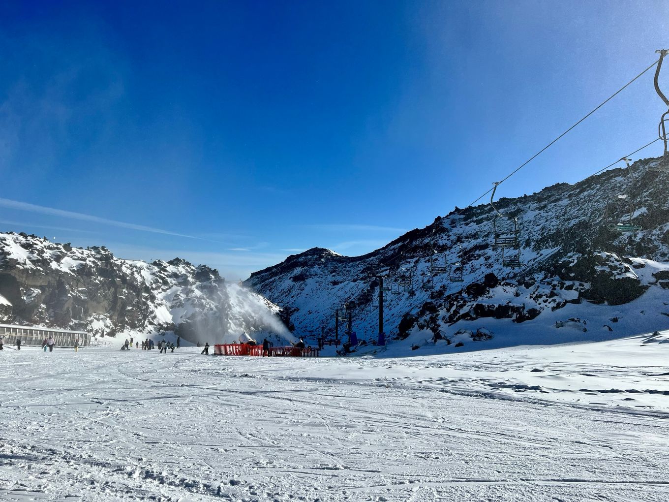 a snow covered mountain with a ski lift in the background.