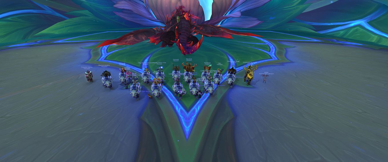 Player characters in the game World Of Warcraft standing around the defeated boss, Fyrakk The Blazing