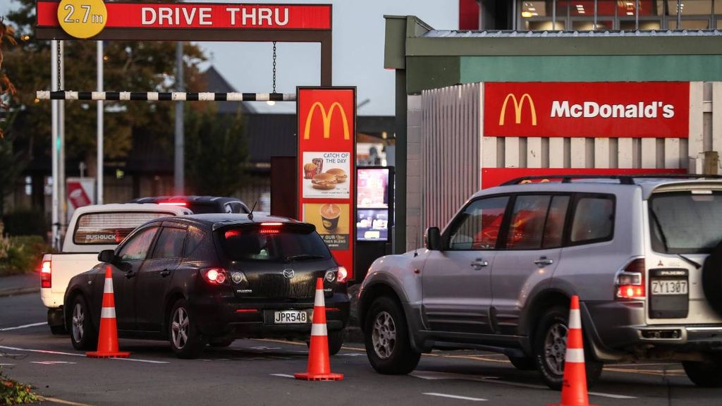 A McDonald's drive thru sign in front of a McDonald's